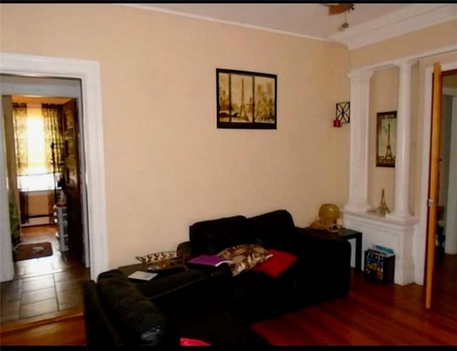 interior space with ornate columns, wood-type flooring, and a baseboard radiator