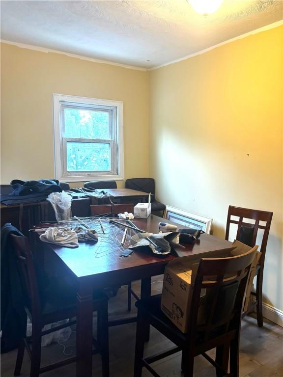 dining space featuring ornamental molding and wood-type flooring