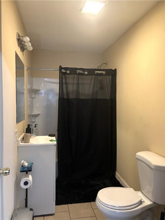 bathroom featuring toilet, tile patterned flooring, a shower with curtain, and vanity