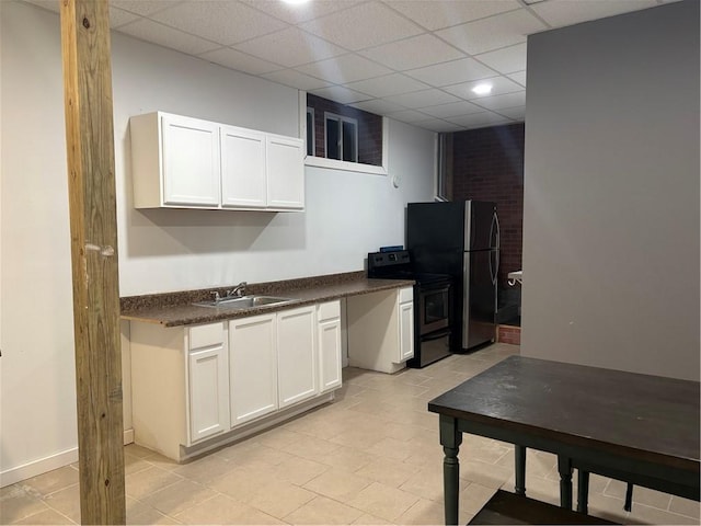 kitchen featuring electric range oven, a paneled ceiling, white cabinetry, sink, and stainless steel fridge