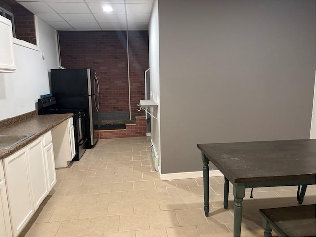 kitchen with sink, white cabinetry, black / electric stove, and a drop ceiling