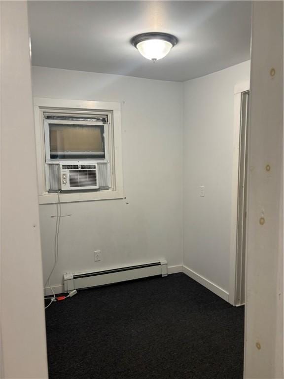 empty room with a baseboard radiator, dark carpet, and cooling unit