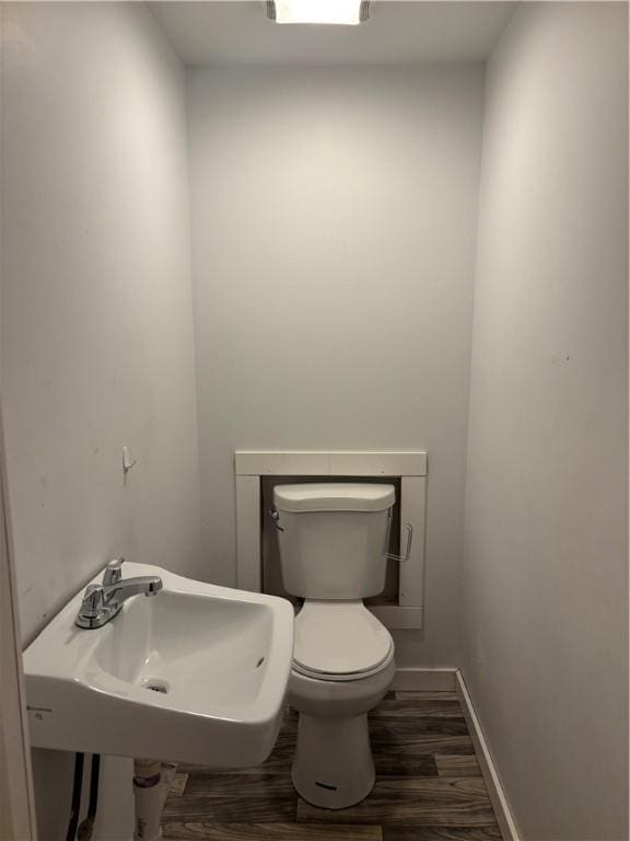 bathroom with hardwood / wood-style flooring, sink, and toilet