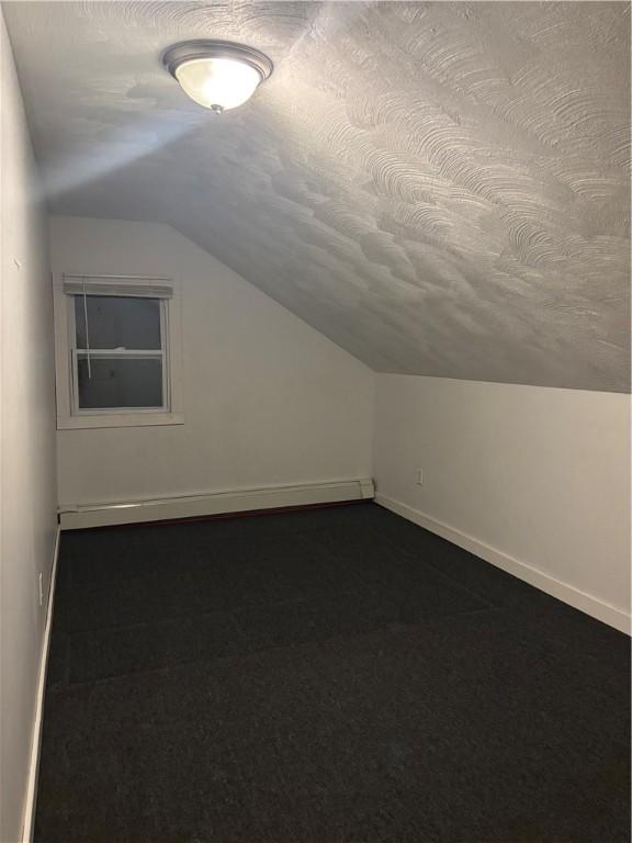 bonus room with vaulted ceiling and a textured ceiling