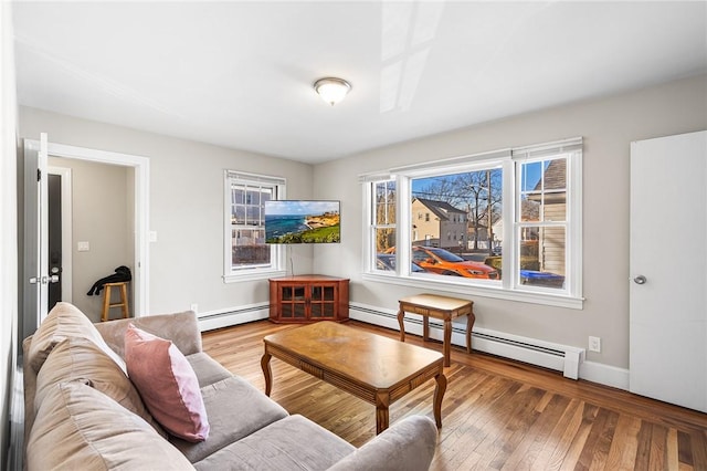 living room featuring a baseboard heating unit and light hardwood / wood-style flooring