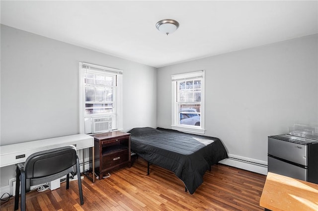 bedroom featuring baseboard heating and dark hardwood / wood-style floors