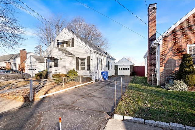 view of front facade featuring a garage, a front lawn, and an outdoor structure