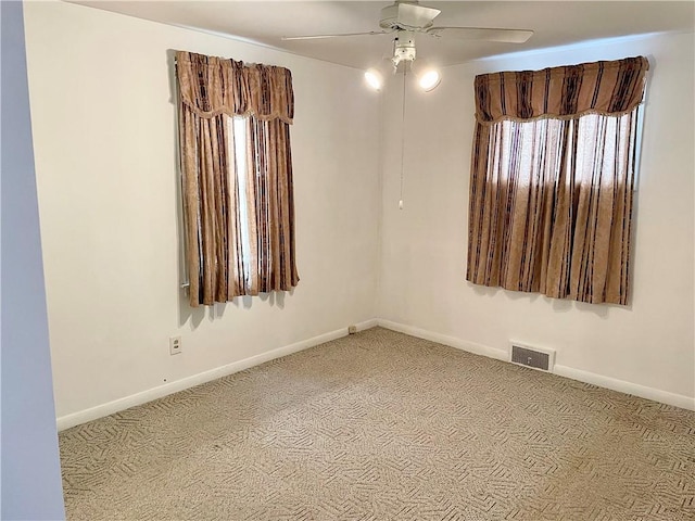 carpeted spare room with ceiling fan and a wealth of natural light