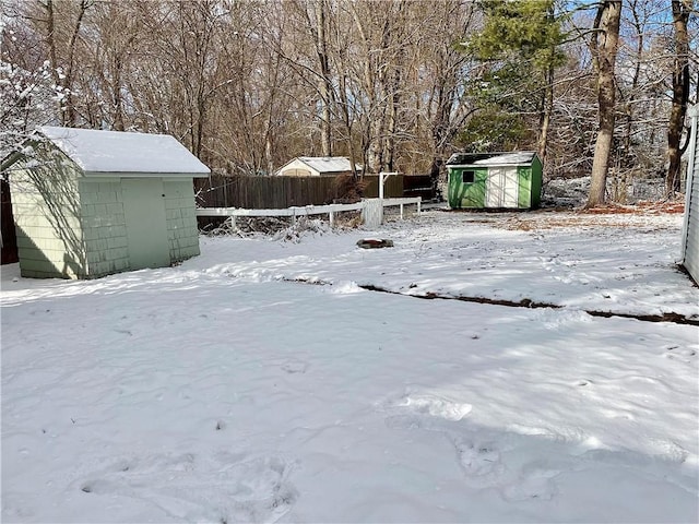 yard covered in snow featuring a storage shed