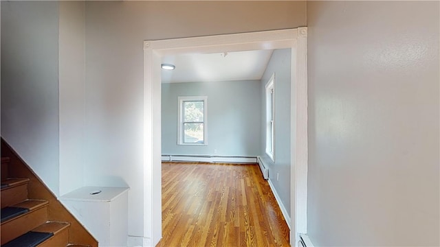 hall featuring a baseboard radiator and light hardwood / wood-style flooring