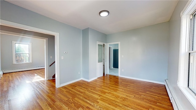 empty room with light hardwood / wood-style flooring and a baseboard heating unit