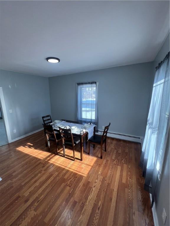 dining room with dark wood-type flooring and a baseboard radiator