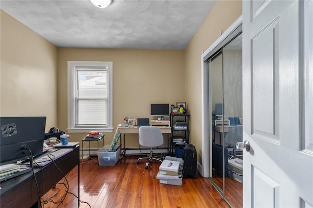 office area featuring a baseboard heating unit and hardwood / wood-style flooring