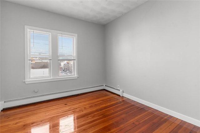 spare room featuring wood-type flooring and a baseboard radiator