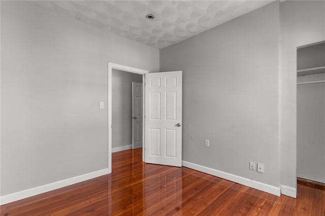 unfurnished bedroom with a closet and hardwood / wood-style floors