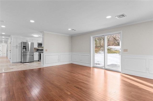 unfurnished living room with light hardwood / wood-style flooring and ornamental molding