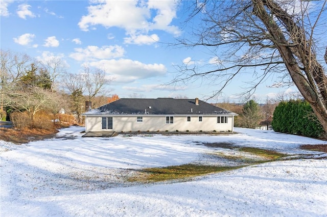 view of snow covered rear of property