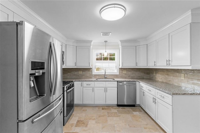 kitchen with white cabinetry, appliances with stainless steel finishes, pendant lighting, light stone counters, and sink