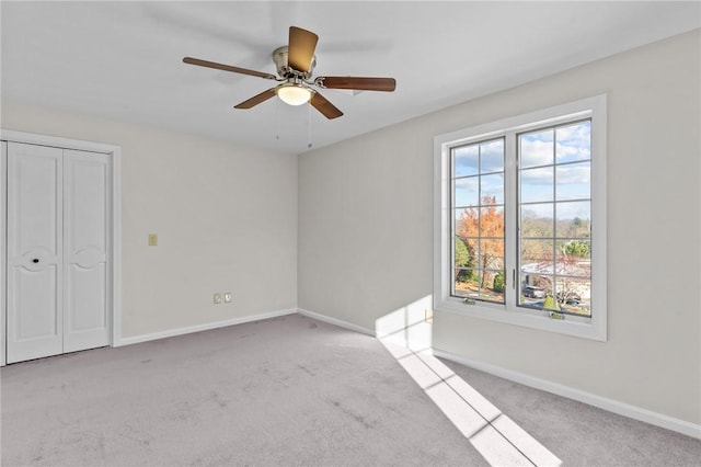 unfurnished bedroom with ceiling fan, light colored carpet, and a closet