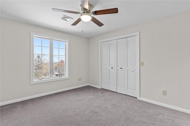 unfurnished bedroom featuring ceiling fan, a closet, and light carpet