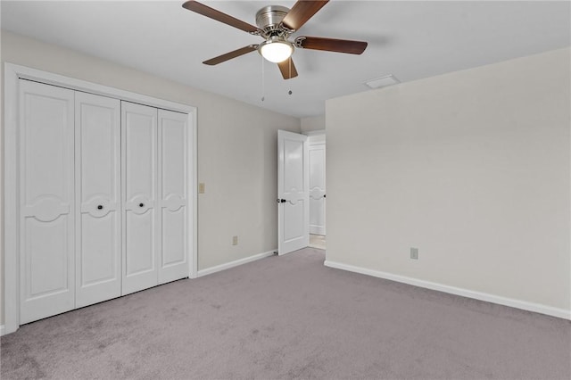 unfurnished bedroom featuring ceiling fan, a closet, and light carpet