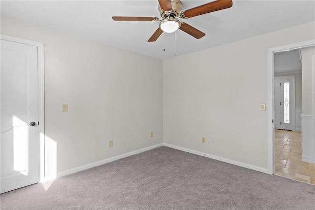 carpeted spare room featuring ceiling fan