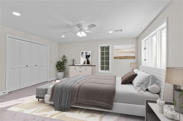 bedroom featuring ceiling fan, light colored carpet, and a closet