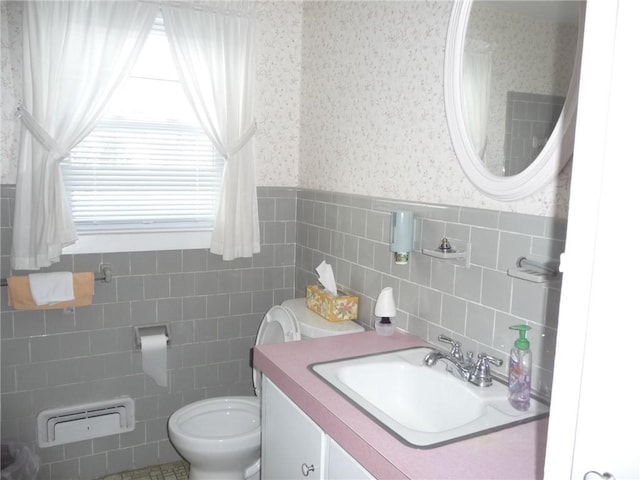 bathroom featuring plenty of natural light, tile walls, toilet, and vanity