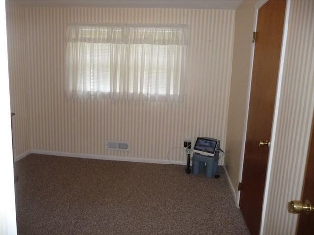 spare room featuring dark carpet