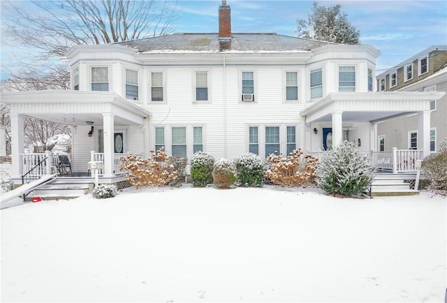 snow covered house featuring a porch