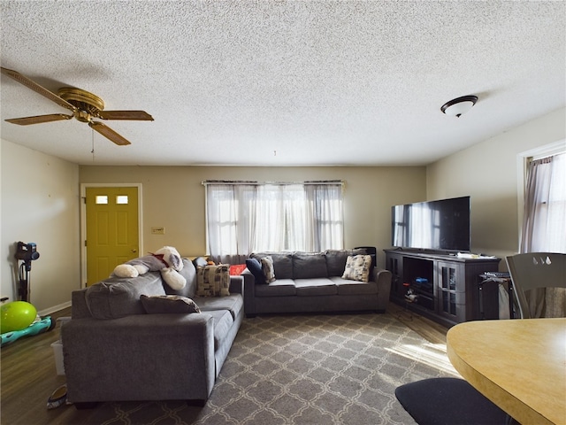 living room featuring ceiling fan, hardwood / wood-style flooring, and a textured ceiling