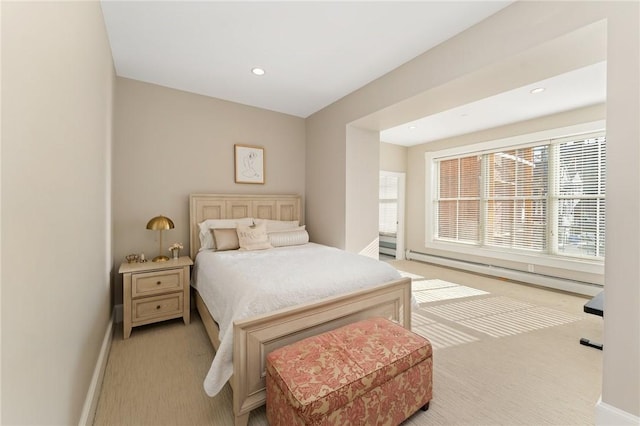 bedroom featuring baseboard heating and light colored carpet