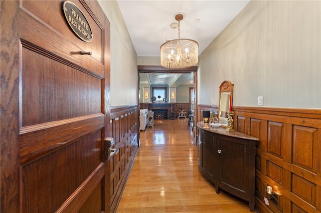 hall with an inviting chandelier and light wood-type flooring