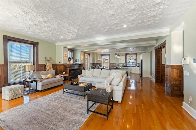 living room featuring hardwood / wood-style flooring, a wealth of natural light, and crown molding