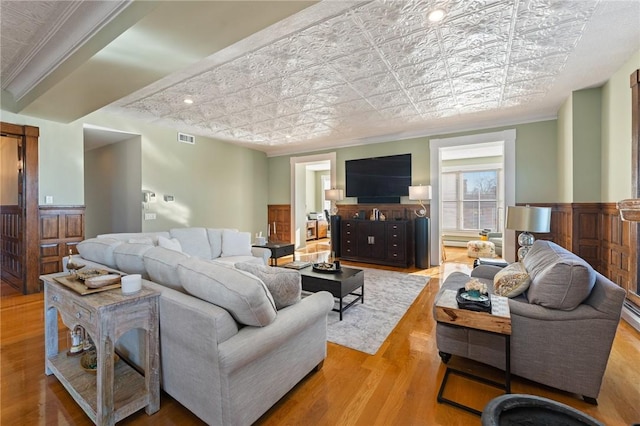 living room with light hardwood / wood-style floors and crown molding