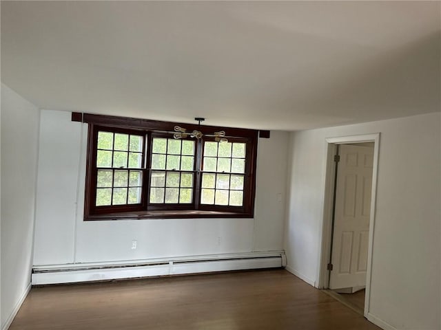 unfurnished room with a baseboard radiator and wood-type flooring