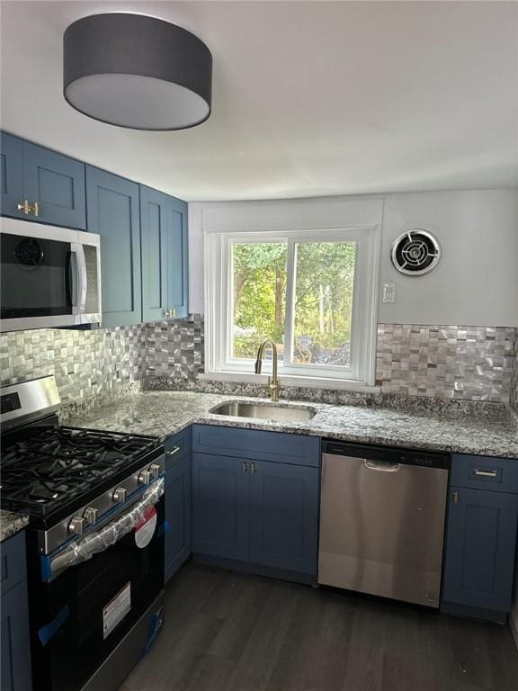 kitchen with sink, blue cabinetry, appliances with stainless steel finishes, and dark wood-type flooring