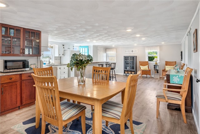 dining space featuring sink and light wood-type flooring