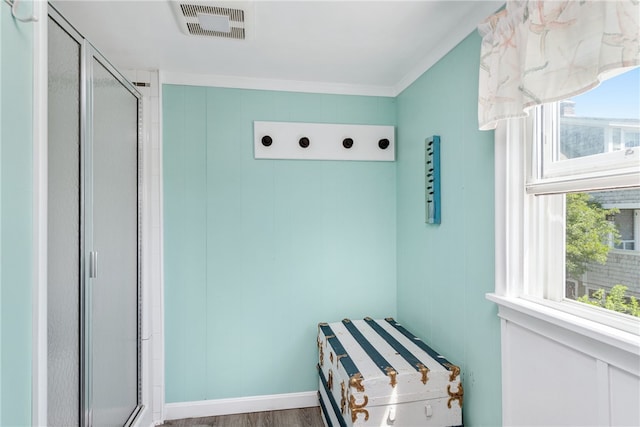 bathroom featuring wood-type flooring, walk in shower, and crown molding