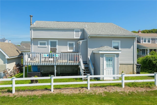 view of front of house with a deck and a front lawn