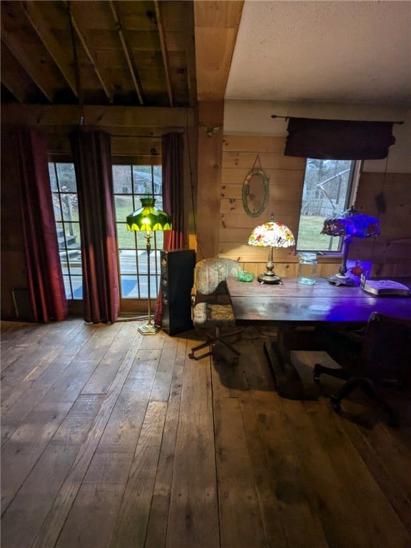 unfurnished dining area with wood ceiling, wood walls, beam ceiling, and wood-type flooring