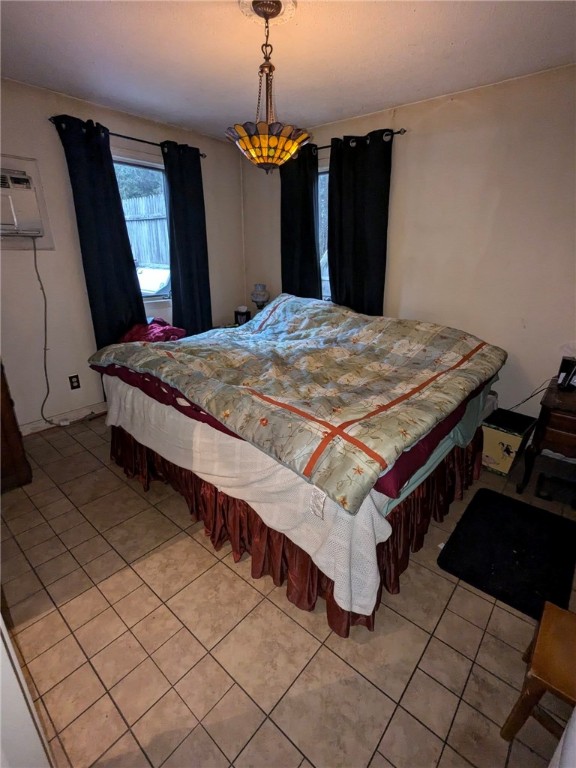 bedroom featuring a wall mounted AC and light tile patterned floors