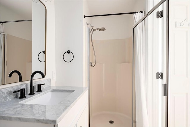 bathroom with vanity and a shower with door