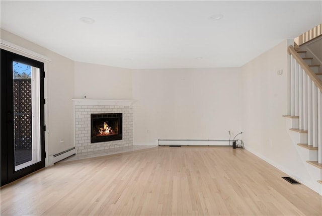 unfurnished living room featuring a baseboard radiator, a fireplace, and light wood-type flooring