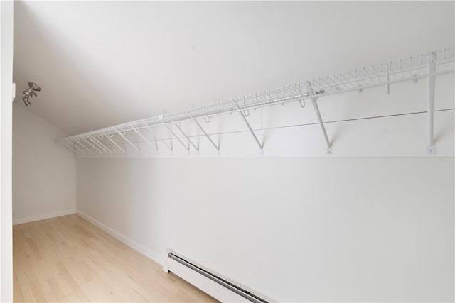 spacious closet featuring a baseboard radiator and light wood-type flooring