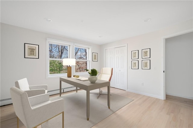 office space with a baseboard heating unit and light wood-type flooring