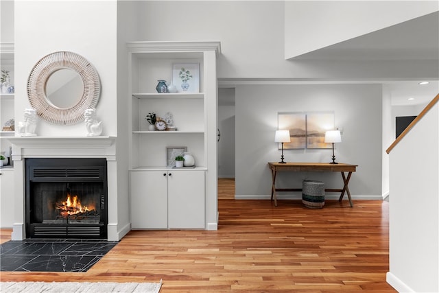 interior space with built in shelves and light hardwood / wood-style flooring