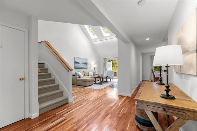 interior space with hardwood / wood-style floors and lofted ceiling with skylight