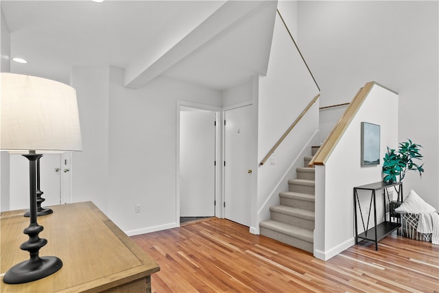 entryway with light wood-type flooring and beamed ceiling