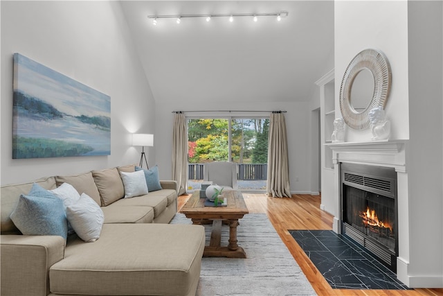 living room featuring wood-type flooring, built in features, and high vaulted ceiling